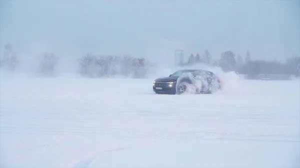 Snöig väg i skogen med bil av och göra en 180 sväng slowmotion. Bilen gör en drift i snön. Bil rider på en snöig väg vintertid — Stockfoto