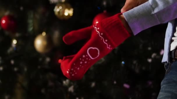 Extender la mano en guante de lana roja sobre fondo de Navidad, concepto de alegría en invierno. Hombre con una manopla de Navidad en la mano — Vídeos de Stock