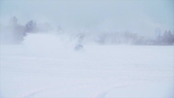 Автомобиль едет по заснеженной дороге, замедленная съемка. Автомобиль с зимними шинами установлен на легкосплавных колесах на снежной улице. Автомобиль, движущийся по снежной дороге зимой — стоковое видео