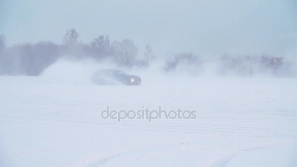 Route enneigée dans la forêt avec voiture et faire un 180 tourner au ralenti. La voiture dérive dans la neige. Balades en voiture sur une route enneigée en hiver — Video