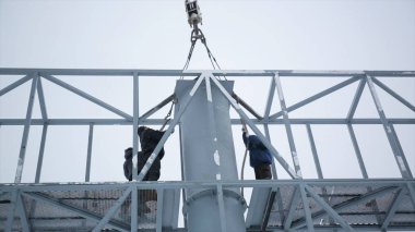 Oluşturucu bir inşaat sahasında Asansör bir platformda. Erkekler işte. İskele site bina montajı inşaat işçisi. Adamları Billboard dokunun üzerinde topla.