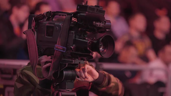 Cameraman using black professional digital video camera. Setup and working. Professional cameraman with headphones with camcorder in live television — Stock Photo, Image