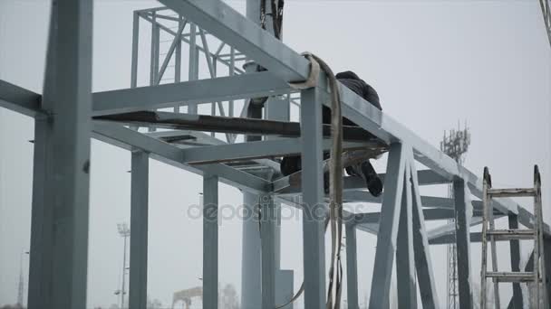 Sur le chantier, les soudeurs au travail. L'homme travaille sur une structure métallique — Video