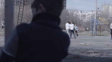 Bankta oturan çocuk. Arkadaşları oynarken bankta oturan çocuk. Yalnızlık kavramını