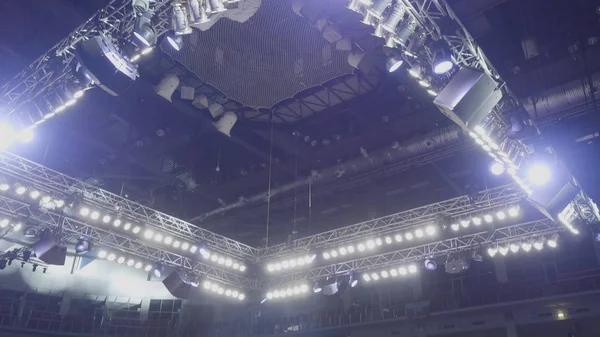 Uma vista de cima do teto de um palco de concerto com holofotes vermelhos e brancos. Spotlights acima do palco. Luzes teatrais claras acima do palco e no console — Fotografia de Stock