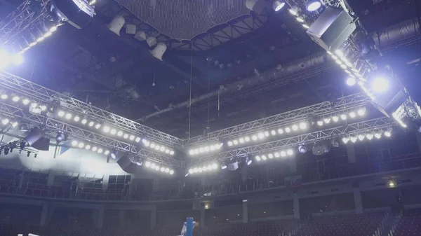 Una vista desde arriba del techo de un escenario de concierto con focos rojos y blancos. Proyectores sobre el escenario. Proyectores de luz sobre el escenario y en la consola —  Fotos de Stock