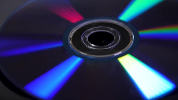 Disk kompak diisolasi pada latar belakang hitam. Makro abstrak menutup refleksi pelangi penuh warna dari cakram padat. Latar belakang abstrak berwarna. Pelangi pada CD — Stok Video