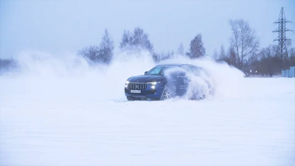 Τα αθλητικά αυτοκίνητα οδηγούν στο χιόνι. Η μηχανή δείχνει την ικανότητα να οδηγείτε σε ένα χιονισμένο δρόμο, παρασυρόμαστε και ελιγμοί — Φωτογραφία Αρχείου