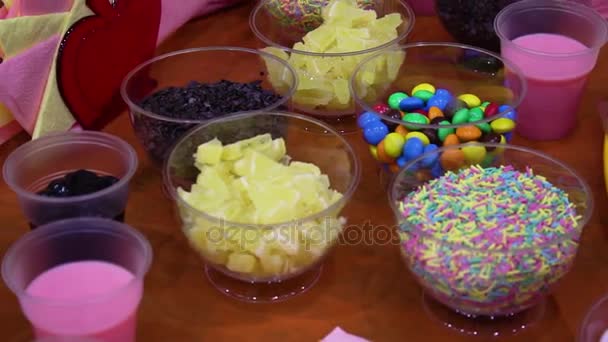 Doces coloridos em jarros na mesa. Doces na mesa. Deliciosos doces em buffet de doces — Vídeo de Stock