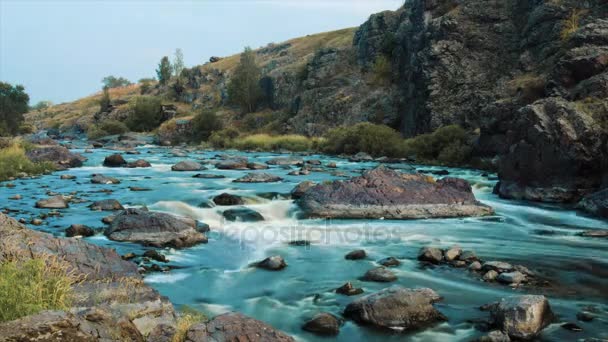 Piękna rzeka wody przepływającej przez kamienie i skały o świcie. Wideo. Przepływ rzeki przez kamienie. Timelapse — Wideo stockowe
