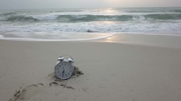 Tiempo de vacaciones. Reloj despertador en la arena. Vídeo. Vigila la playa. Observa tumbado en la arena del mar simbolizando un tiempo de descanso — Vídeos de Stock
