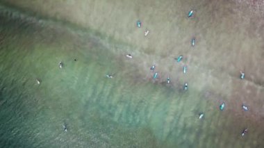 Gemide büyük mavi okyanus dalgası Yüzme sörfçü hava görünümünü. Sörfçü dalgaları için bekleyen bir sürü dron görünümü. Bulutsuz bir günde bir dalga okyanusun bekliyor sörfçü bir havadan görünümü