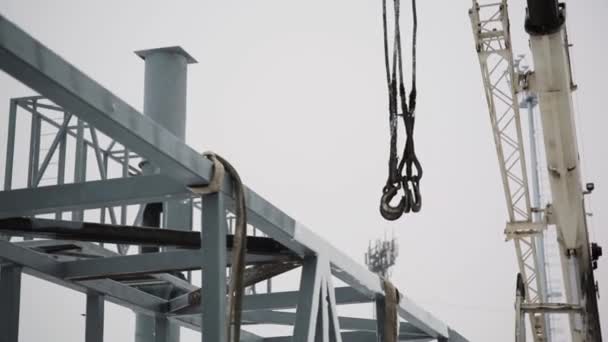 Guindaste é usado na construção de edifícios. equipamento de guindaste de construção sobre canteiro de obras e levar o trabalhador para o local alto no dia. Contexto do estaleiro — Vídeo de Stock