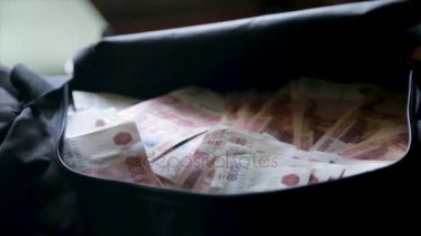 Siyah çanta para nakit kapatın. Siyah çanta para destesi. Gri arka plan üzerinde para dolu