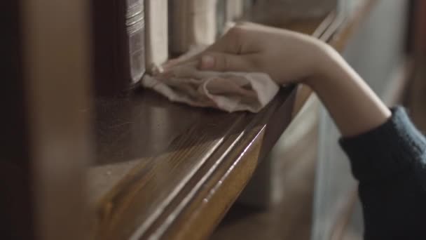 Gros plan d'enfants essuyant à la main une poussière sur la bibliothèque. Nettoyez l'étagère. Les garçons nettoient la bibliothèque à la main. Essuyer la poussière. Vue du dessus de l'enfant nettoyant la bibliothèque et essuyant la poussière — Video