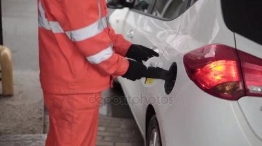 Araba Servis istasyonunda dolumu benzin istasyonu işçi. Küçük. Erkek gaz görevlisi arabayı doldurur