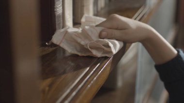 Kitaplığa toz silen bir çocuğun eline yakın çekim. Çocuk rafı temizliyor. Çocuğun eli kitaplığı temizliyor. Tozu siliyorum. Çocuğun kitaplığı temizlediği ve tozları sildiği en iyi manzara..