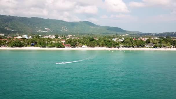Luchtfoto van wit zand strand en jet ski op de blauwe lagune aqua-zee. Luchtfoto vogels eye weergave van jetski varen in hoge snelheid in de zee turkoois helder water — Stockvideo
