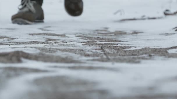 Close-up van mannelijke benen in winter schoenen lopen op sneeuw. Beeldmateriaal, weergave van lopen op sneeuw met sneeuwschoenen en schoen pieken in de winter. Mens benen in laarzen close-up van het met sneeuw bedekte pad — Stockvideo