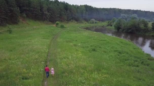 Paar spaziert im Wald in der Nähe des Flusses. Clip. junges verliebtes Familienpaar spaziert im Sommer im Wald am Fluss — Stockvideo