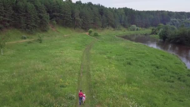 Paar wandelen in het woud in de buurt van de rivier. Clip. Jonge familie paar verliefd wandelen in het woud in de buurt van de rivier in de zomer — Stockvideo