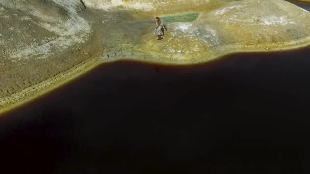 Vista aérea de la niña corre a través del terreno montañoso, paisaje natural con un fondo de lago. Filmación. Mujer viajero escalada a las montañas cumbre lago azul vista aérea Travel Lifestyle — Vídeos de Stock