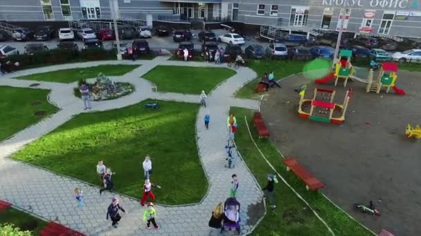 Widok z góry całkiem małych dzieci jest uruchomiony na zielonej trawie, uśmiechając się i patrząc na kamery. Klip. Dzieci w parku Spójrz w górę — Wideo stockowe