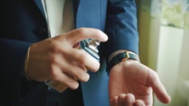 Yakın çekim yakışıklı iş adamı veya parfüm kullanarak damat. Klip