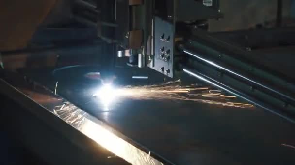 Industriële laser cutter met vonken. Clip. De geprogrammeerde robot hoofd snijdt met behulp van een groot vel metalen temperatuur. Close-up — Stockvideo
