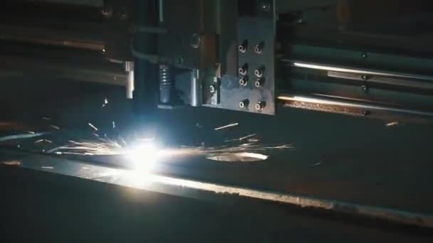 Industriële laser cutter met vonken. Clip. De geprogrammeerde robot hoofd snijdt met behulp van een groot vel metalen temperatuur. Close-up — Stockvideo