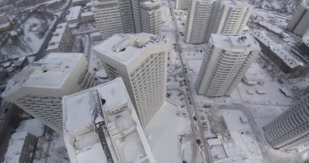 Letecký pohled na zasněžené město. Klip. Moderní bydlení okres je v popředí a město na pozadí — Stock video