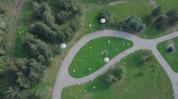 緑豊かな公園や日当たりの良い春の日にその広大な芝生。クリップ。空中歩行パスとグリーン ゾーン木市立公園の無人機の飛行から。公園のサイクリスト — ストック写真