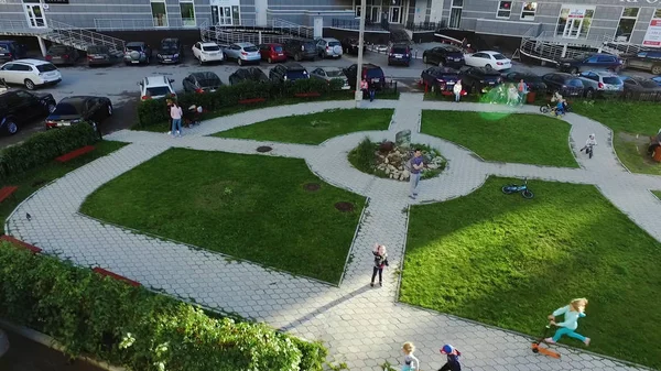 Bovenaanzicht van mooie kleine kinderen draait op groen gras, glimlachend en camera kijken. Clip. Kinderen in het Park kijken boven — Stockfoto