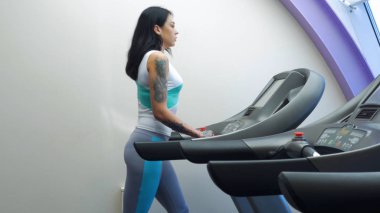 Spor egzersiz, koşu bandı üzerinde çalışan aktif genç kadın. Bir makinede çalıştırın. Spor salonunda makine üzerinde çalışan genç sportif kadın. Bir kadın bir koşu bandı üzerinde koşu.