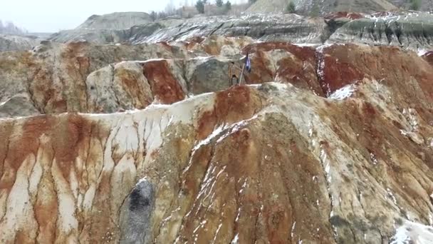 Succes leiderschap, prestatie en mensen concept - jonge man met de vlag op de bergtop. Beeldmateriaal. Man met een vlag op de top van een berg — Stockvideo