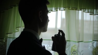 Kolonya veya parfüm kullanarak takım elbise zarif adam. Klip. Adam parfüm kullanır