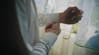 Yakın çekim görünümü genç erkek el sabah giyiniyor. Küçük. Adam düğmeleri Kelepçe için hazırlanıyor bir gömlek, iş