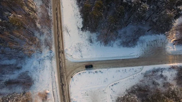 Cruce en forma de T en el bosque nevado en el día de invierno. Vista aérea. Filmación. Paseos en coche por cruce en el bosque cubierto de nieve en el día de invierno. Vista aérea . — Foto de Stock