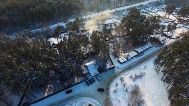 冬の日に雪の森で T 字交差点。空撮。映像。冬の日に雪に覆われた森の十字路で車に乗る。航空写真ビュー. — ストック動画