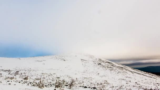 Bewegende winter briefkaart: besneeuwde heuvels. Dramatische wolken vorm in een vallei. Uitzicht vanaf de top van een berg. Video. Wolken die bewegen snel onthullen een Snow Mountain boslandschap Time-Lapse gevuld. — Stockvideo