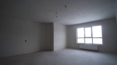 Yenileme iç. Küçük. Pencere ve beton döşeme ile boş beyaz duvar.