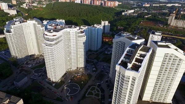 Vista dall'alto di un moderno complesso residenziale con alte belle case. Clip. Una grande finestra in un condominio. Molte finestre su edificio in mattoni — Foto Stock