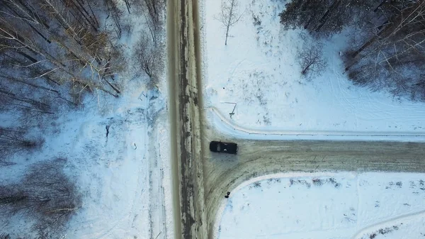 Vista superior del coche que monta en el bosque. Filmación. El coche va en un camino de invierno en el bosque — Foto de Stock