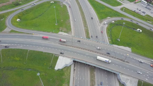 Вид с воздуха на перекресток автострады. Клип. Шоссе и эстакада с машинами и грузовиками, развязка, двухуровневый перекрёсток в большом городе. Вид сверху . — стоковое фото