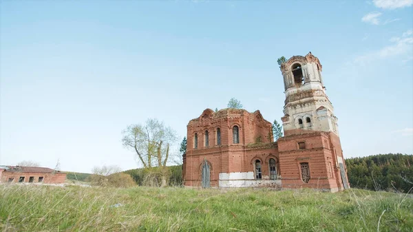 Ruinas de una iglesia abandonada de ladrillos rojos en Rusia. Vídeo. Al aire libre en el campo sobre fondo azul cielo de verano. Hermosa vista panorámica del antiguo templo budista en el fondo del campo . —  Fotos de Stock