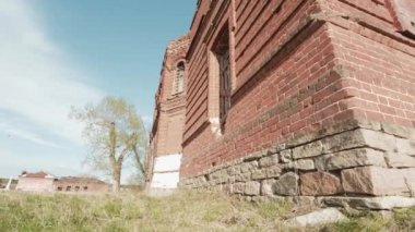 Sonbahar mavi gökyüzü çayır alana terk edilmiş kilisede. Video. Sarı çiçekli bir alandaki küçük Şapel. Eski yıkık kilisenin. Kalıntılar mavi gökyüzü arka plan üzerinde. Yeşil çim sahası