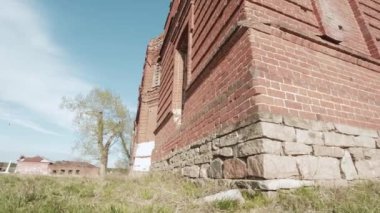 Sonbahar mavi gökyüzü çayır alana terk edilmiş kilisede. Video. Sarı çiçekli bir alandaki küçük Şapel. Eski yıkık kilisenin. Kalıntılar mavi gökyüzü arka plan üzerinde. Yeşil çim sahası