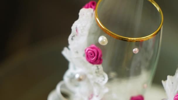 Fermer les verres à champagne avec du champagne rose et du sucre doré sur le bord. Vidéo. Lunettes pour un mariage sur fond gris — Video