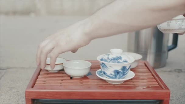 伝統的な中国のお茶会です。ビデオ。男性の手のクローズ アップは、中国茶のカップを設定します。中国式のお茶を飲みます。お茶を飲むを提供 — ストック動画