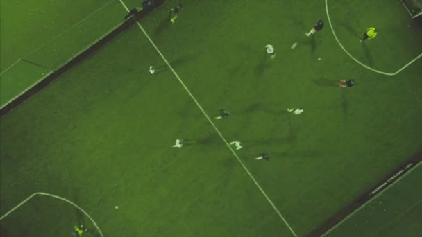 Partita di calcio aerea. Clip. Aerial shot Due squadre che giocano a pallone all'aperto, vista dall'alto. Gioco di calcio all'aperto, campo verde con segnapunti, giocatori che corrono in giro con una palla — Video Stock